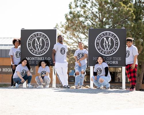 Montbello students pose in front of school sign 